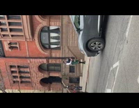 Guy wearing green kilt plays bagpipes outside 