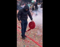 Man rolls out firecrackers on street for new year while firecrackers explode