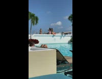 Woman in violet bikini with coverups poses by the pool