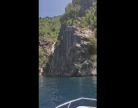 Two guys jump off cliff into ocean 