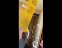 Drunk girls wear yellow wet floor cones on their heads in the bathroom