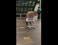 Woman sits on computer chair at station