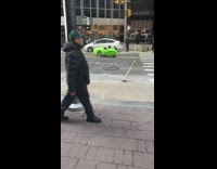 person in small green car