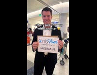 Husband picks-up wife at airport with only fans sign