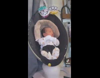 Baby in baby seat rocker moving arms around dancing 