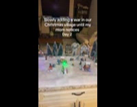 Woman puts soldier toys on Christmas Village