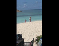 Woman in blue bikini white dress poses at the beach