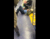 Man lays down comfortably in subway floor