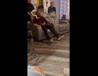 Snake crawls on man sitting on couch