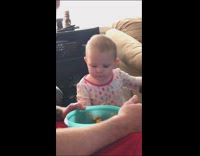 Baby spits single cereal back into blue bowl