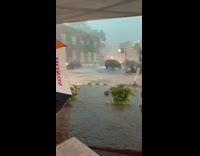 Guy sits table white canopy umbrella drink 