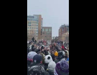 People in crowd at park cheer when shirtless guy gets lifted up