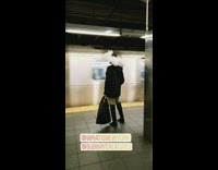 Woman wears a large feather hat at subway station