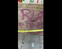 Wood board blocks off hole in sidewalk 