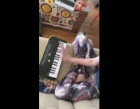 Woman plays keyboard piano with space cat leggings on couch