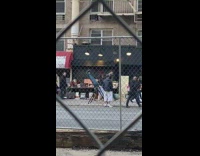 Man lays upside down on teeter back pain inversion seat on the sidewalk