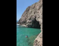 Guy does backflip from side of cave 