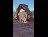 Girl stand under stone arch national park