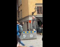 Woman pink hair stands on barrier to pose