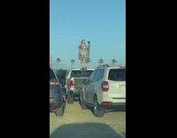 Woman in shiny dress vlogs on the car roof