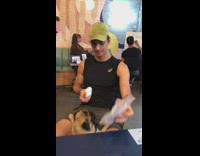 Guy green hat dog jumping water treat