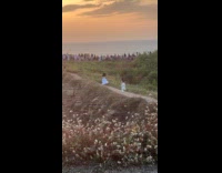 Woman white dress run for video near beach