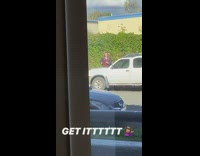 Red shirt leather jacket sidewalk grass hedge