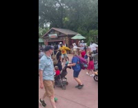 Man yellow sweater dances with Disney crew and shouts