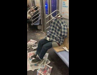 Clothes stuffed with pillows, looks like person sitting on subway, no head