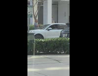 IITW - Man takes picture of woman leaning on white car