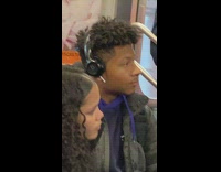 Guy wears Beats headphones on top of airpods on subway train