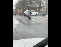 Man struggles to transport grill on scooter 