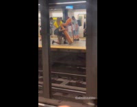 Man kneels and plays harp at subway