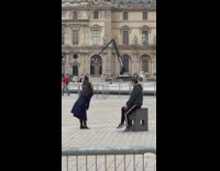 Woman in black coat tiktok dance in front of bored man