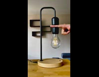 Floating black lightbulb magnetic lamp turns on