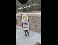 Guy white mcdonalds sign on back sidewalk 