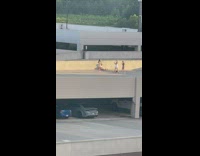 Women poses at the rooftop parking lot at sunset