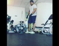 White shirt guy lifts curls two dumbbells 