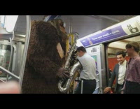 Bigfoot costume blue bandana plays saxophone on the subway train passengers enter