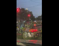Man in green convertible car with drawings