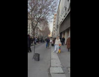 Woman in a jacket poses with a  skateboard near a line