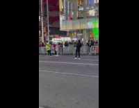 Man in black outfit dances on the side of the street