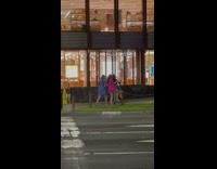 Three women dance outside Hermes store night