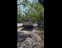 FedEx driving down the sidewalk