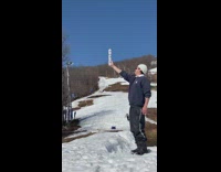 Skier grabs beer off a beer can stack after a flip