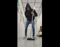 Guy dances uses blue broom as mic 