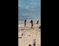 Woman in bikini peace sign at the beach