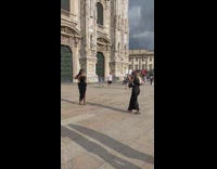 Woman black dress glovers pose outside church