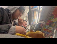 Girl eating rotisserie chicken while riding subway