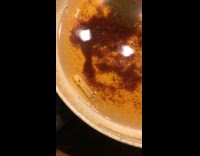 Food swims around the cooking oil inside the frying pan.